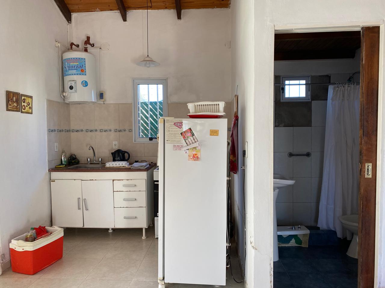 Cocina con termotanque y baño al fondo de Lo De Ely